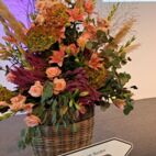 Wegweiser Frauen in Führung im Norden an einen Korb mit Herbstblumen gelehnt auf der Bühne.