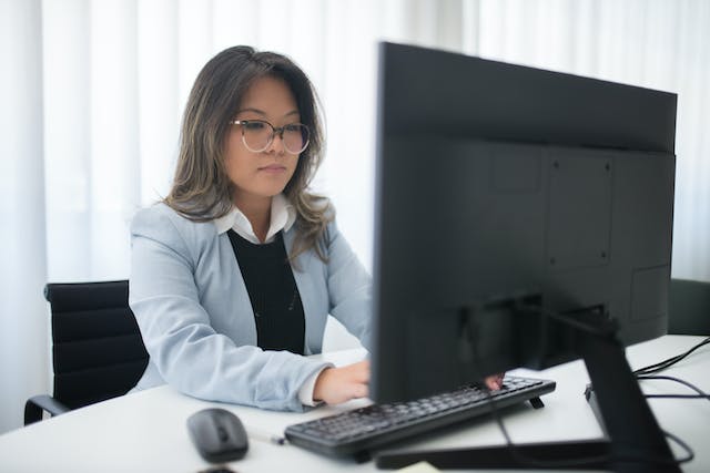Frau sitzt am Schreibtisch und arbeitet im Online-Coworking.